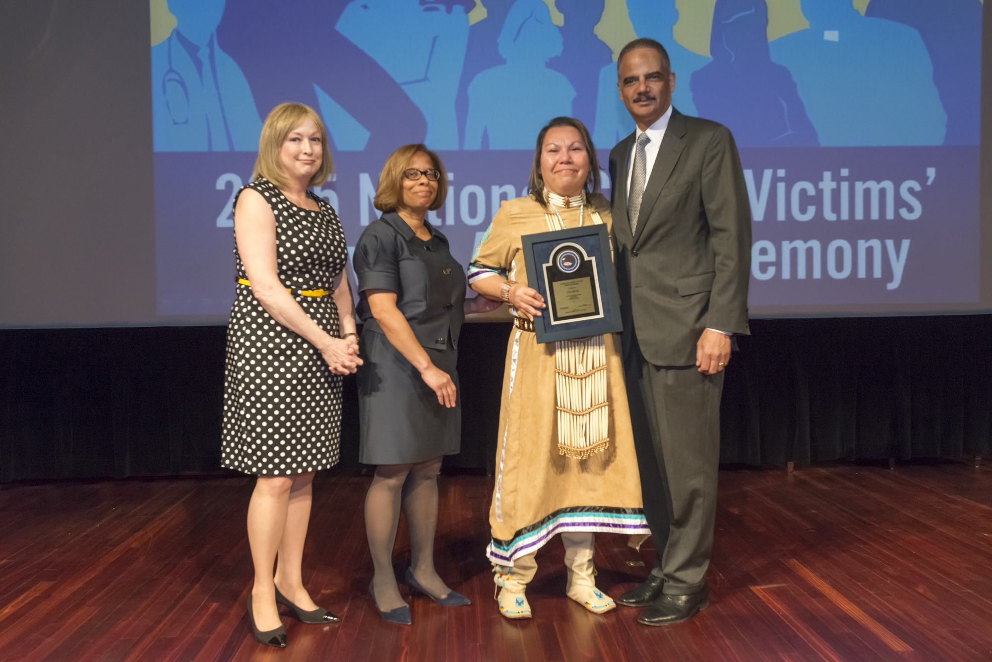2015 National Crime Victim Service Award recipient Lisa Heth with (from left) Joye E. Frost, Director, Office for Victims of Crime; Karol V. Mason, Assistant Attorney General, and Attorney General Eric H. Holder, Jr.