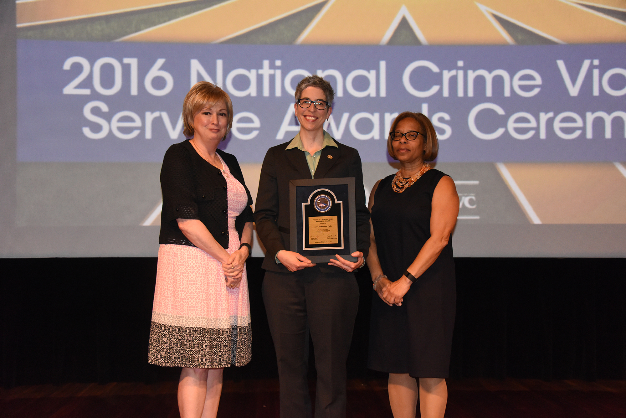 2016 Crime Victims Research Award recipient Anne P. DePrince, Ph.D. accepts the award with (from left) Joye E. Frost, Director, Office for Victims of Crime and Karol V. Mason, Assistant Attorney General.