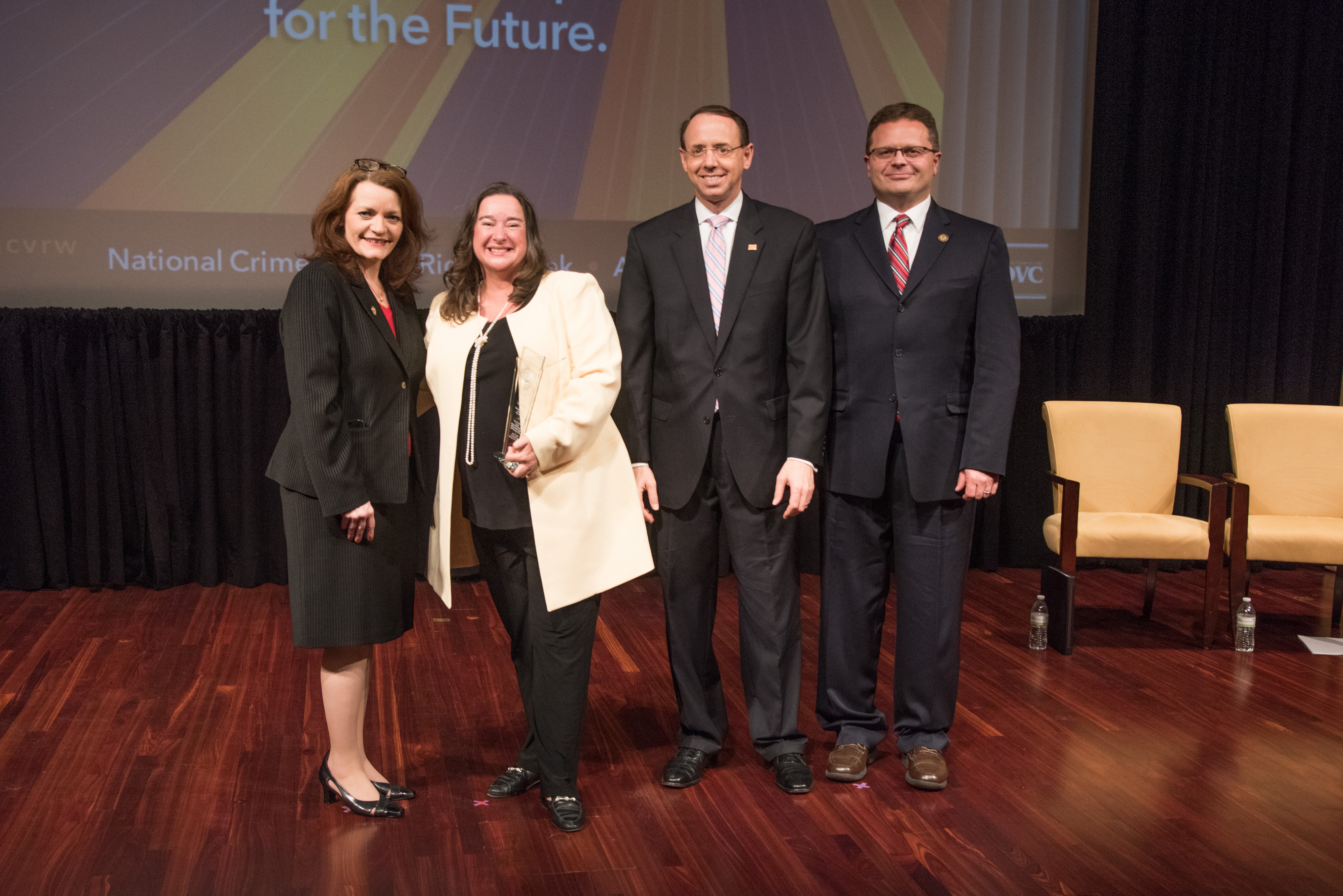 Laura Abbott receives the 2019 Volunteer for Victims Award with (from left) OVC Director Darlene Hutchinson, Principal Deputy Assistant Attorney General for the Office of Justice Programs Matt M. Dummermuth, and Deputy Attorney General Rod J. Rosenstein.