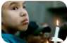 Young child holding candle.