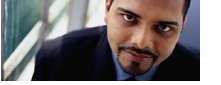 Photo of a man in a suit looking up at the camera.