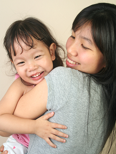 Woman holding child, smiling