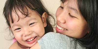 Woman holding child, smiling