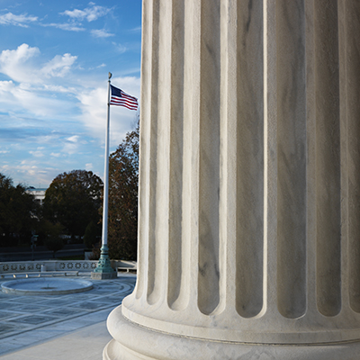 Pillars of justice in foreground, with flag pole and American flag in background