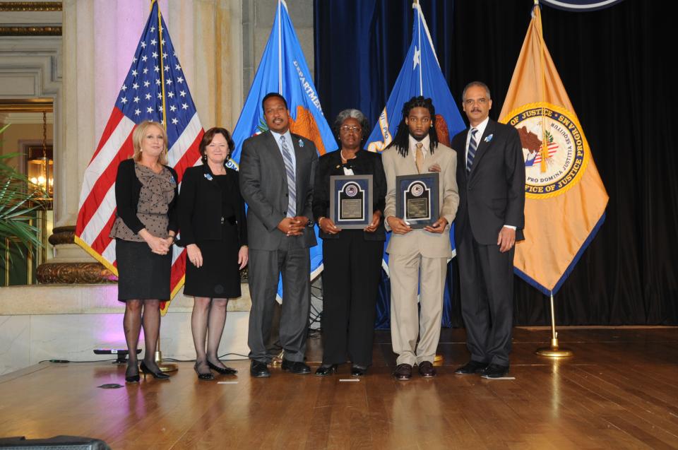 Julia Dunkins and Justin Todd Fennell accept the 2012 Special Courage Award accompanied by (from left) Joye E. Frost, Acting Director, Office for Victims of Crime; Acting Assistant Attorney General Mary Lou Leary, Office of Justice Programs; U.S. Attorney for the District of Columbia Ronald C. Machen; and U.S. Attorney General Eric H. Holder, Jr.