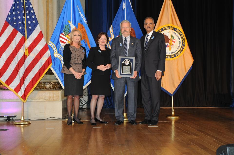 Bruce Ross accepts the 2012 Special Courage Award for Mickey Rooney with (from left) Joye E. Frost, Acting Director, Office for Victims of Crime; Acting Assistant Attorney General Mary Lou Leary, Office of Justice Programs; and U.S. Attorney General Eric H. Holder, Jr.