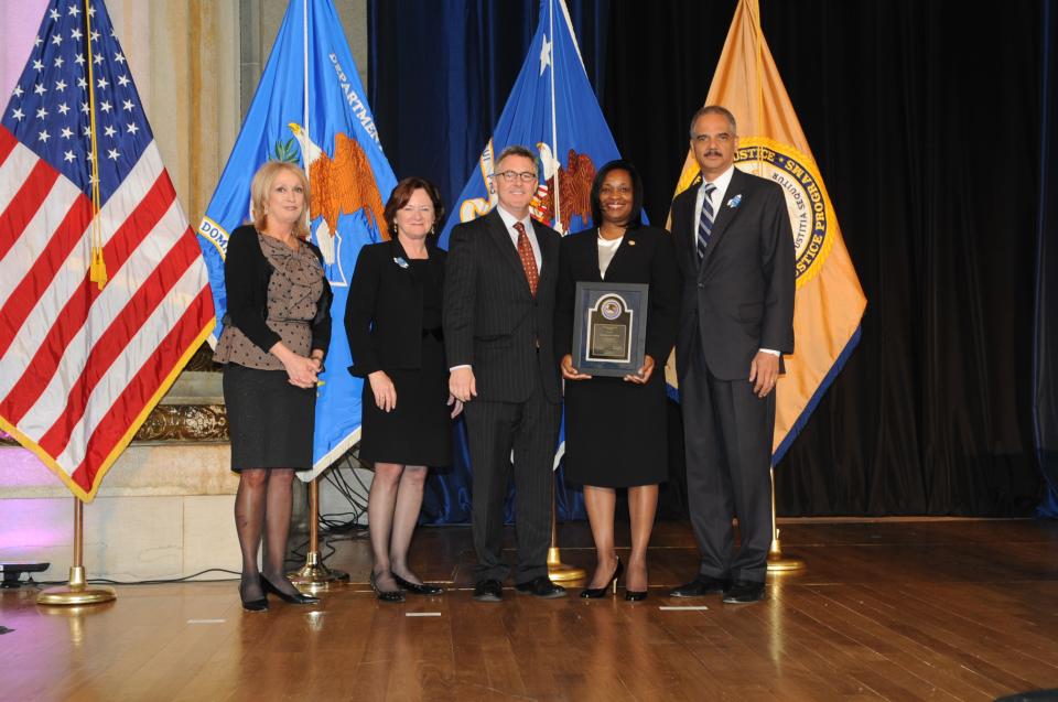 Michelle D. Scott accepts the 2012 Federal Service Award accompanied by Thomas Walker, U.S. Attorney for the Eastern District of North Carolina.