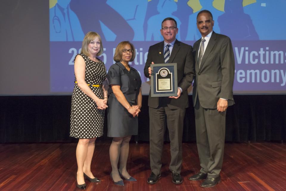 2015 National Crime Victim Service Award recipient Judge Paul M. Herbert with (from left) Joye E. Frost, Director, Office for Victims of Crime; Karol V. Mason, Assistant Attorney General, and Attorney General Eric H. Holder, Jr.
