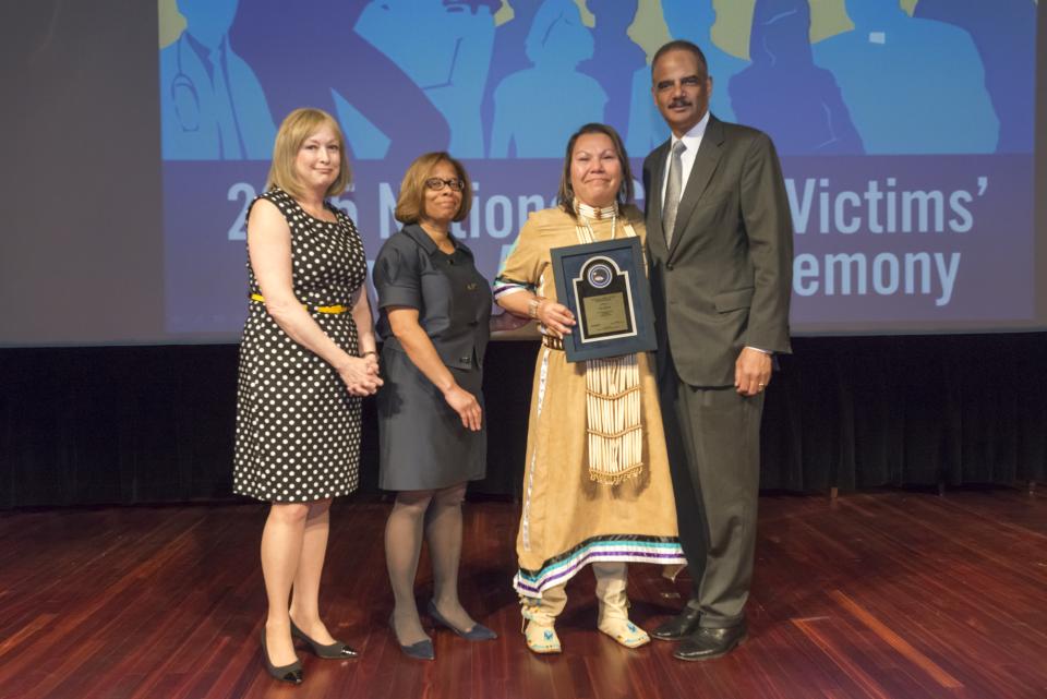 2015 National Crime Victim Service Award recipient Lisa Heth with (from left) Joye E. Frost, Director, Office for Victims of Crime; Karol V. Mason, Assistant Attorney General, and Attorney General Eric H. Holder, Jr.