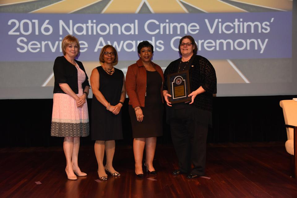 Staff from the Choctaw Nation Victim Services accepts the 2016 Award for Professional Innovation in Victim Services. Linda Goodwin Sr., Director Victim Services, accepts the award with (from left) Joye E. Frost, Director, Office for Victims of Crime; Karol V. Mason, Assistant Attorney General; and Attorney General Loretta E. Lynch.