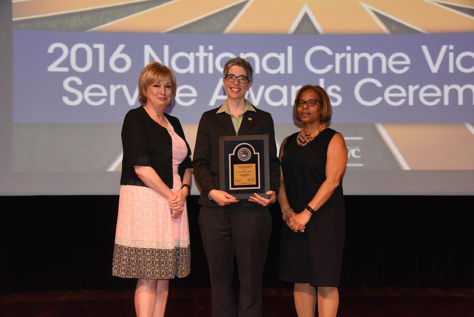 2016 Crime Victims Research Award recipient Anne P. DePrince, Ph.D. accepts the award with (from left) Joye E. Frost, Director, Office for Victims of Crime and Karol V. Mason, Assistant Attorney General.