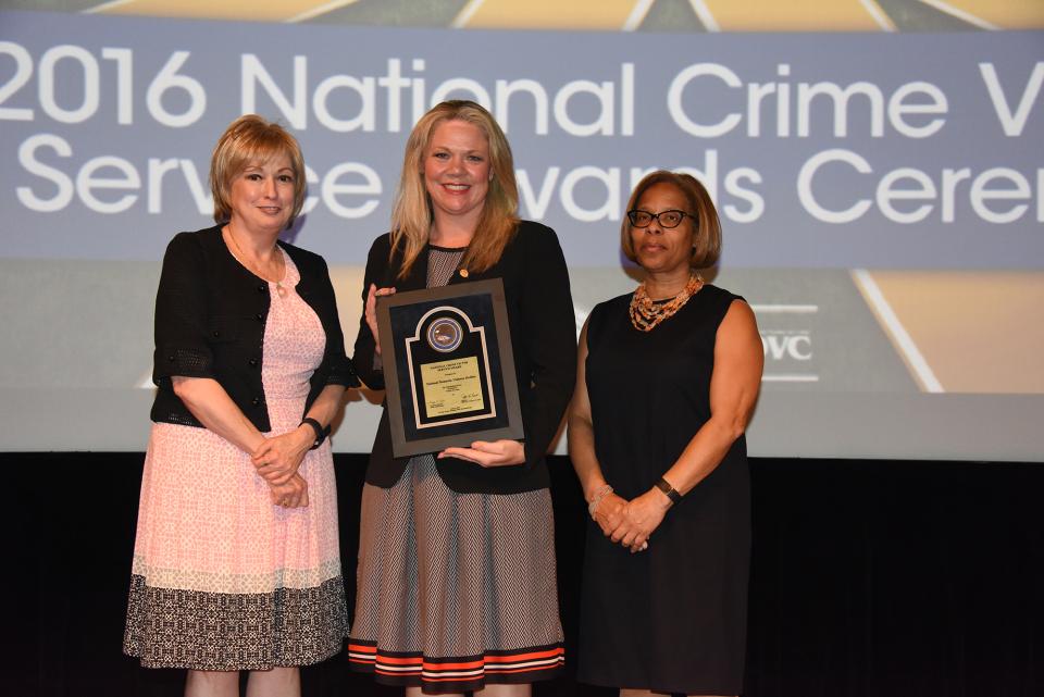 Katie Ray-Jones accepts the 2016 Award for Professional Innovation in Victim Services on behalf of the National Domestic Violence Hotline with (from left) Joye E. Frost, Director, Office for Victims of Crime and Karol V. Mason, Assistant Attorney General.