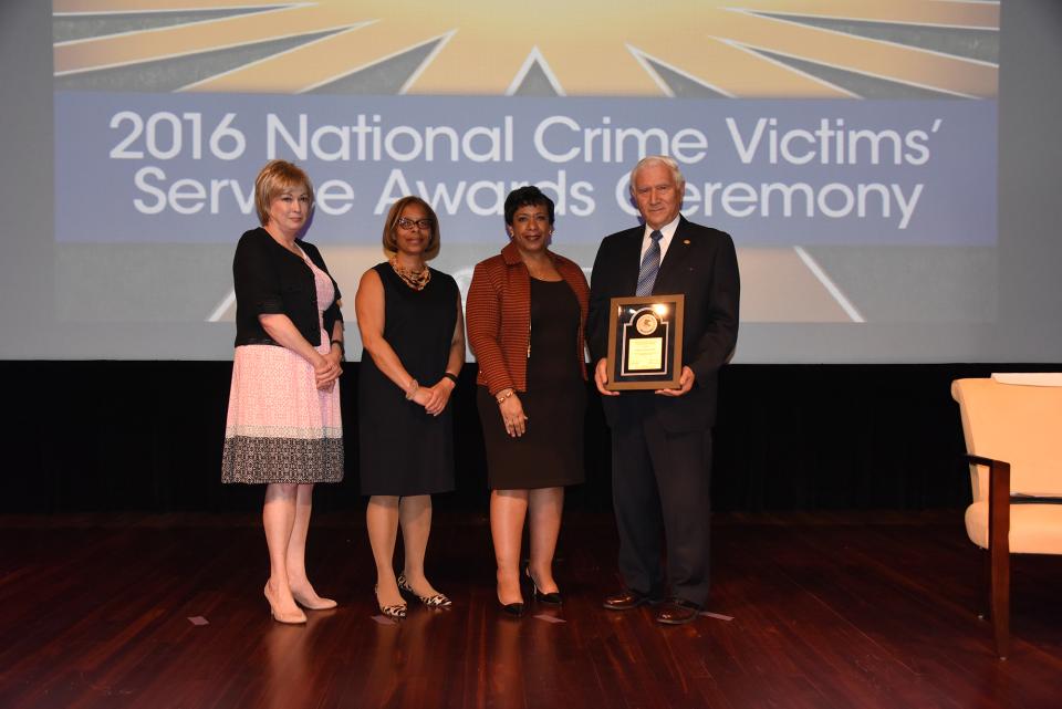 2016 Ronald Wilson Reagan Public Policy Award recipient Dr. John P.J. Dussich with (from left) Joye E. Frost, Director, Office for Victims of Crime; Karol V. Mason, Assistant Attorney General; and Attorney General Loretta E. Lynch.