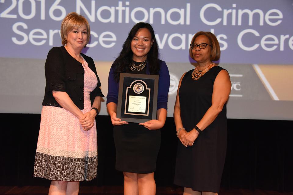 2016 Tomorrow’s Leaders Award recipient Miki Nishizawa accepts the award with (from left) Joye E. Frost, Director, Office for Victims of Crime and Karol V. Mason, Assistant Attorney General.