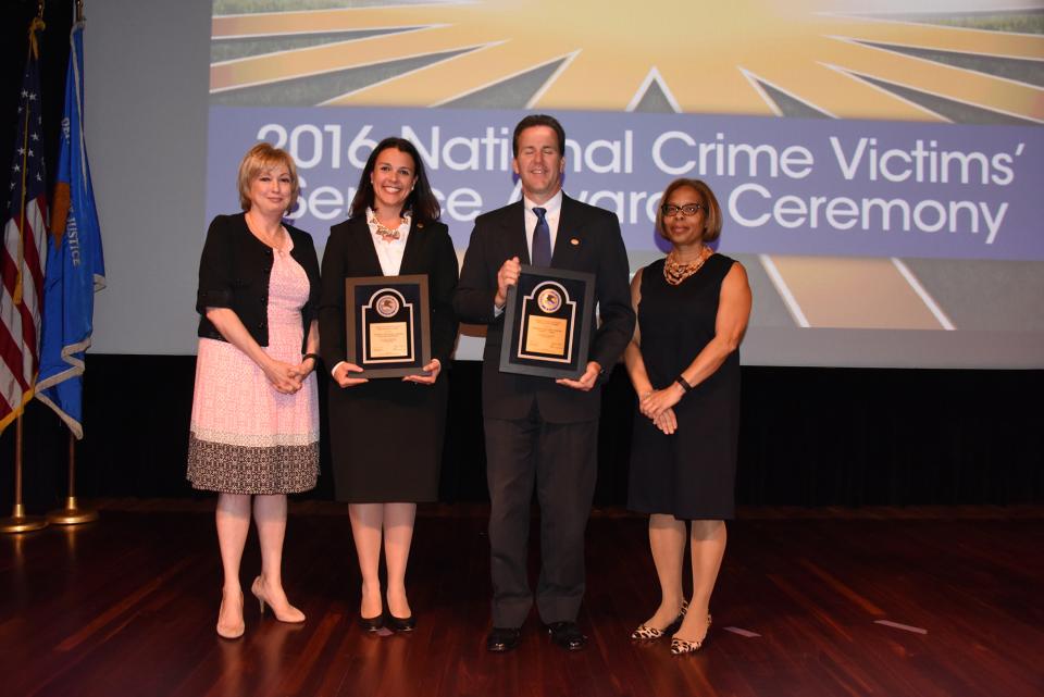 Stephen J. Pfleger and Laura Day Rottenborn accept the 2016 Crime Victims Financial Restoration Award with (from left) Joye E. Frost, Director, Office for Victims of Crime and Karol V. Mason, Assistant Attorney General.