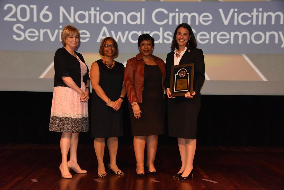 2016 Crime Victims Financial Restoration Award recipient Laura Day Rottenborn with (from left) Joye E. Frost, Director, Office for Victims of Crime; Karol V. Mason, Assistant Attorney General; and Attorney General Loretta E. Lynch.