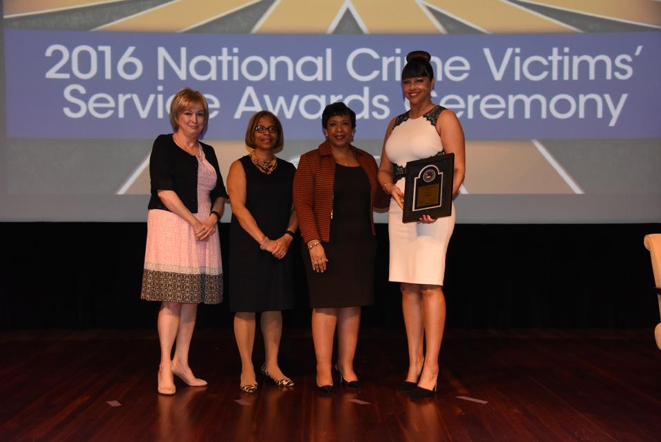 2016 Special Courage Award recipient Brenda Tracy with (from left) Joye E. Frost, Director, Office for Victims of Crime; Karol V. Mason, Assistant Attorney General; and Attorney General Loretta E. Lynch.