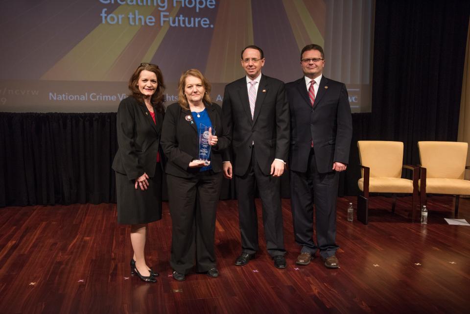 Missey Smith receives the 2019 Ronald Wilson Reagan Public Policy Award with (from left) OVC Director Darlene Hutchinson, Deputy Attorney General Rod J. Rosenstein, and Principal Deputy Assistant Attorney General for the Office of Justice Programs Matt M. Dummermuth.