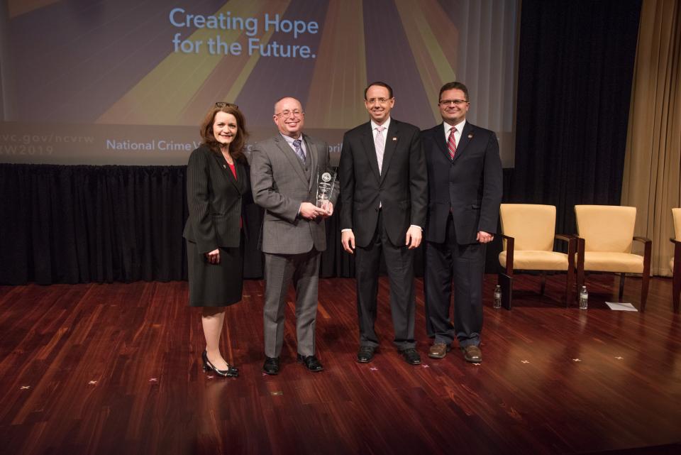 Richard H. Norcross III receives the 2019 Award for Professional Innovation in Victim Services with (from left) OVC Director Darlene Hutchinson, Deputy Attorney General Rod J. Rosenstein, and Principal Deputy Assistant Attorney General for the Office of Justice Programs Matt M. Dummermuth.