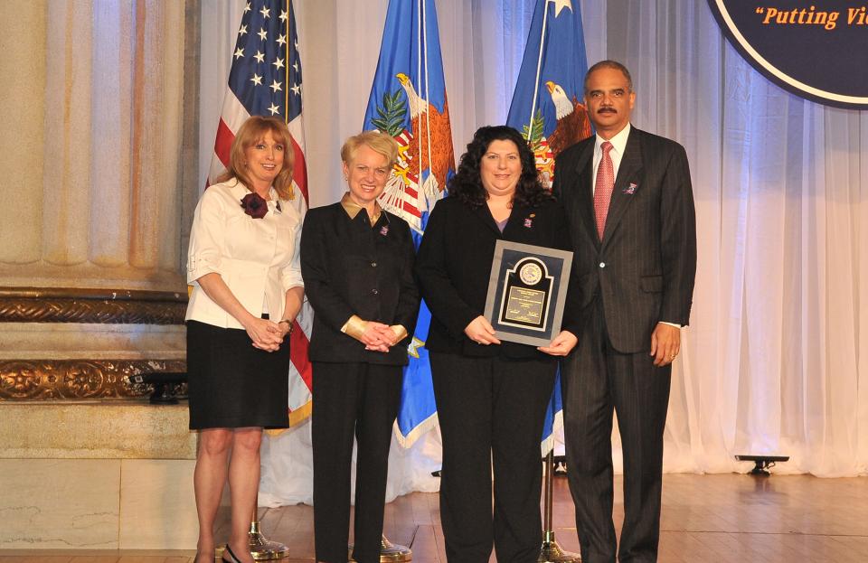 Accepting an award on behalf of the Boston Area Rape Crisis Center (BARCC), Gina Scaramella is pictured with (from left) Joye E. Frost, Acting Director, Office for Victims of Crime; Laurie O. Robinson, Acting Assistant Attorney General, Office of Justice Programs; and U.S. Attorney General Eric H. Holder, Jr.