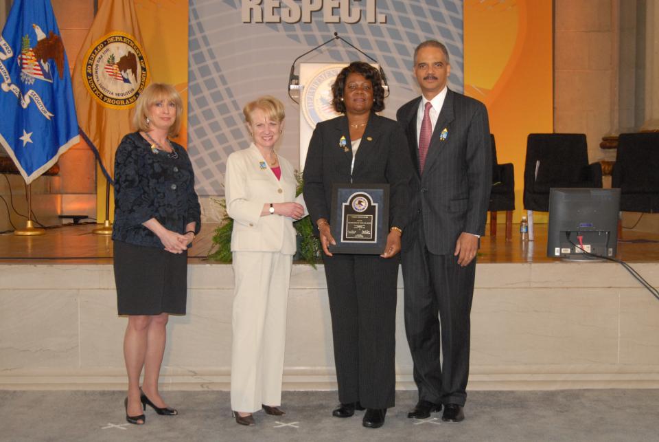 2010 Federal Service Award recipient Verlean K. Brown with (from left) Joye E. Frost, Acting Director, Office for Victims of Crime; Assistant Attorney General Laurie O. Robinson, Office of Justice Programs; and U.S. Attorney General Eric H. Holder, Jr.