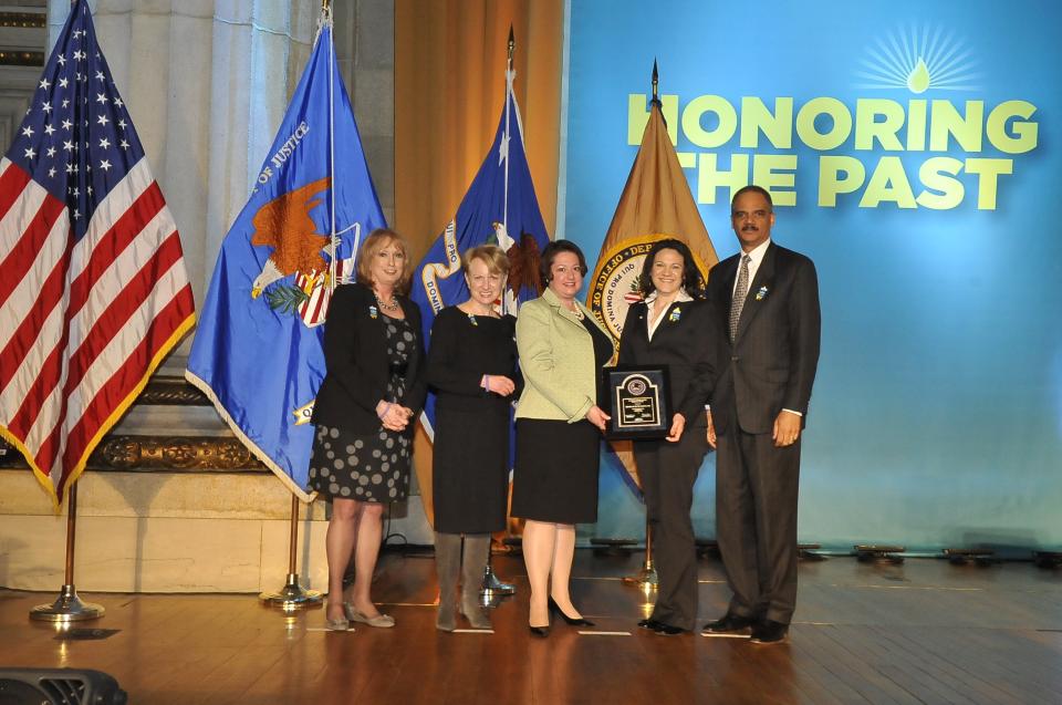 Deena Hausner and Johanna Mauro accept the 2011 National Crime Victim Service Award for the House of Ruth Maryland with (from left) Joye E. Frost, Acting Director, Office for Victims of Crime; Assistant Attorney General Laurie O. Robinson, Office of Justice Programs; and U.S. Attorney General Eric H. Holder, Jr.