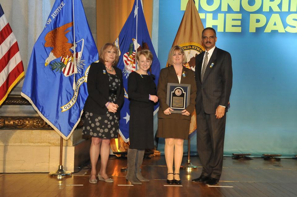 2011 Pamela Faith Young McCarter, M.D., who received the 2011 Volunteer for Victims Award, stands with (from left) Joye E. Frost, Acting Director, Office for Victims of Crime; Assistant Attorney General Laurie O. Robinson, Office of Justice Programs; and U.S. Attorney General Eric H. Holder, Jr.