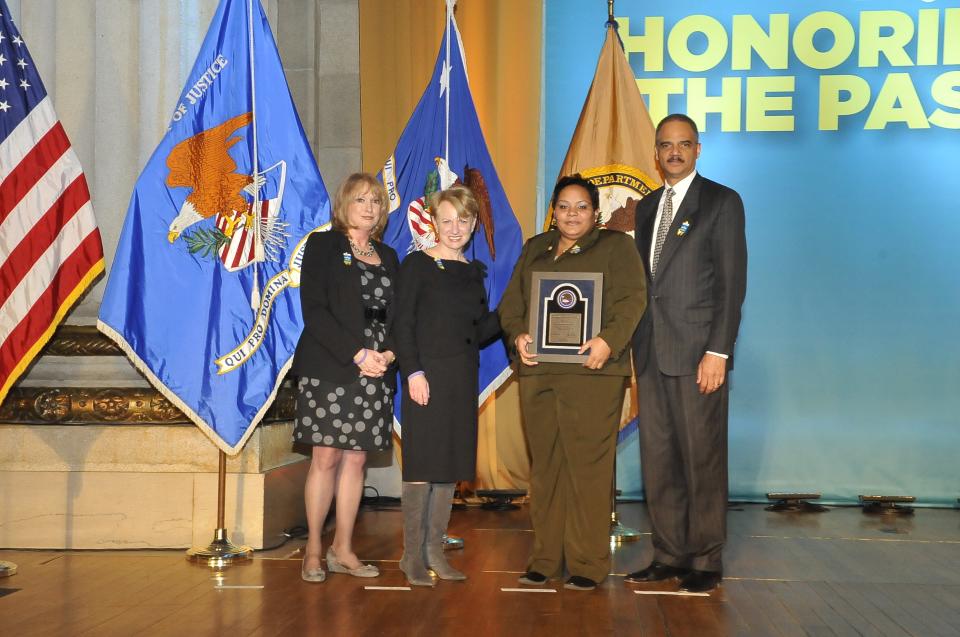 2011 Special Courage Award recipient Nicole M. Robinson stands with (from left) Joye E. Frost, Acting Director, Office for Victims of Crime; Assistant Attorney General Laurie O. Robinson, Office of Justice Programs; and U.S. Attorney General Eric H. Holder, Jr.