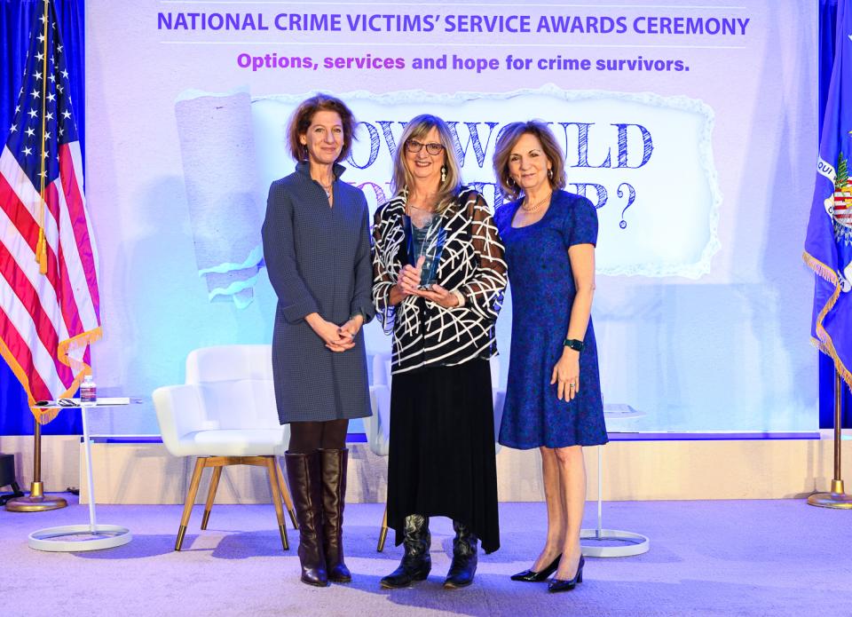 Angela McCown, LMFT receives the 2024 National Crime Victim Service Award with (from left) OVC Director Kristina Rose and Assistant Attorney General Amy L. Solomon.