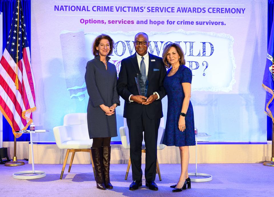 Herman Millholland receives the 2024 National Crime Victim Service Award with (from left) OVC Director Kristina Rose and Assistant Attorney General Amy L. Solomon.