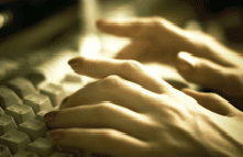 Photo of hands typing on a computer keyboard.