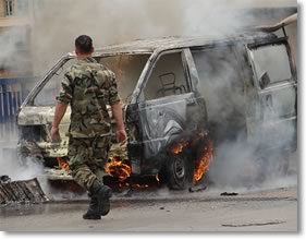 Photo of a solidier walking towards a car crash