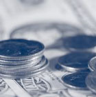Photo of coins stacked on a dollar bill.
