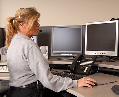 woman seated at computer terminal with hand on computer mouse